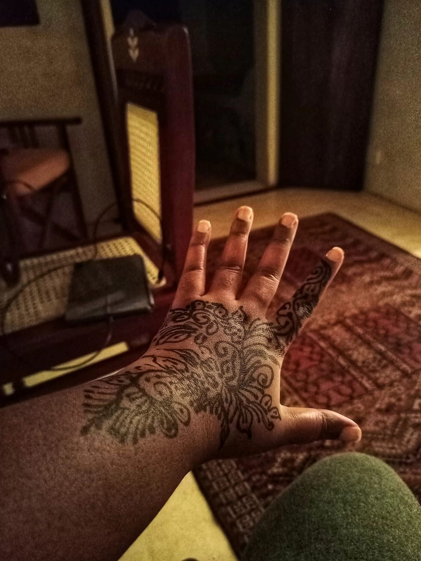 a woman showing henna design on her left hand