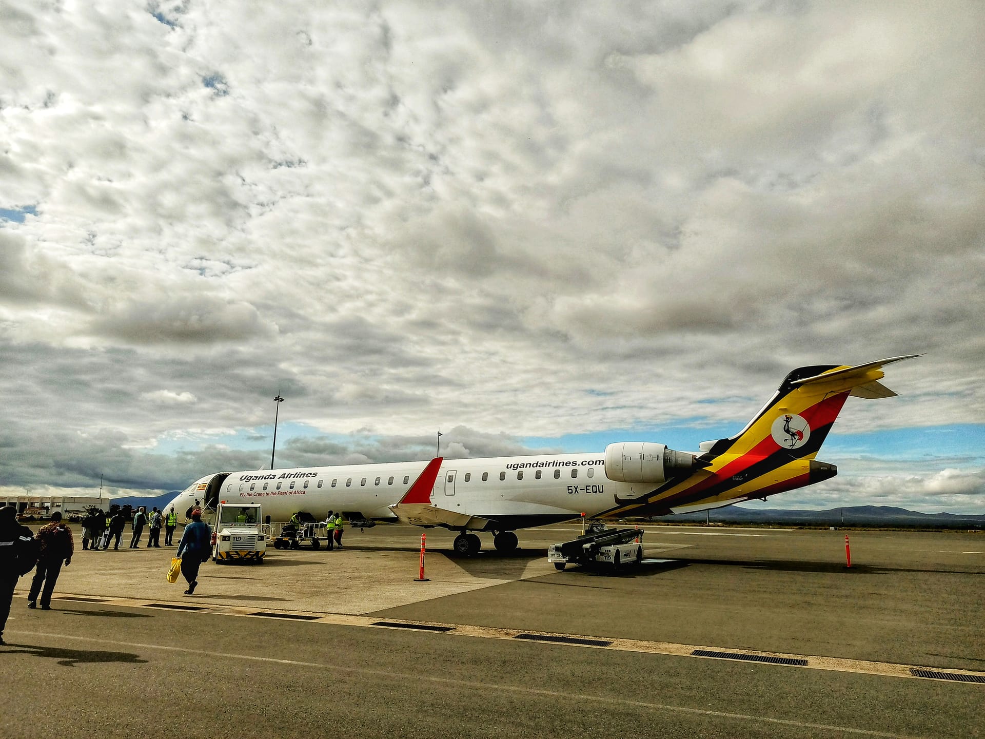 picture showing people walking towards a Uganda Airlines flight